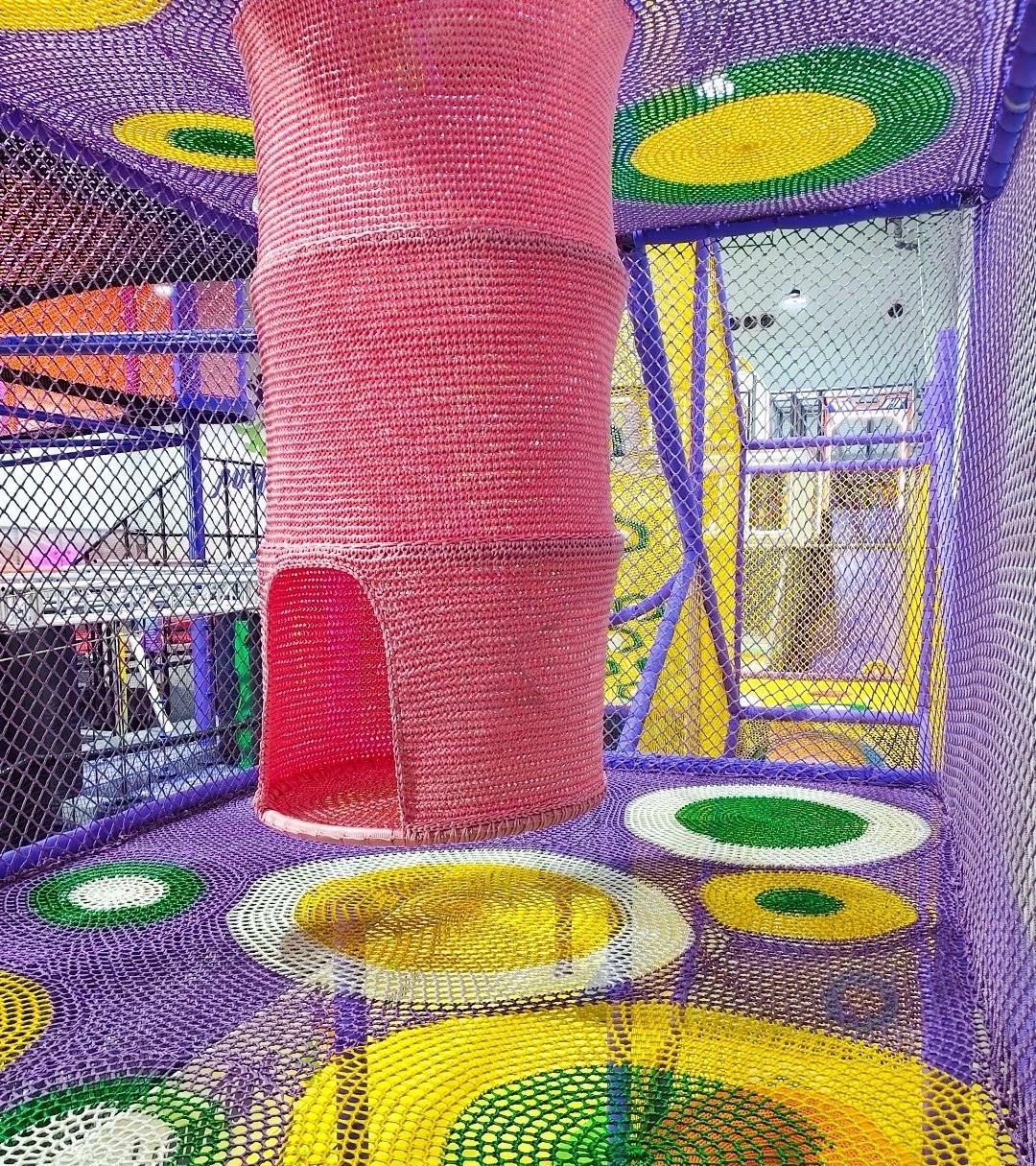 Crochet rope climbing net in purple and white inside a play atrium
