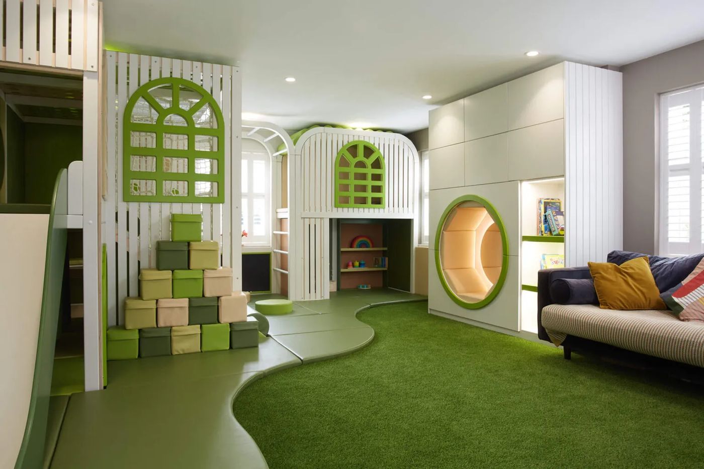Habitat Collection natural timber indoor playground with white cabins and a large lawn