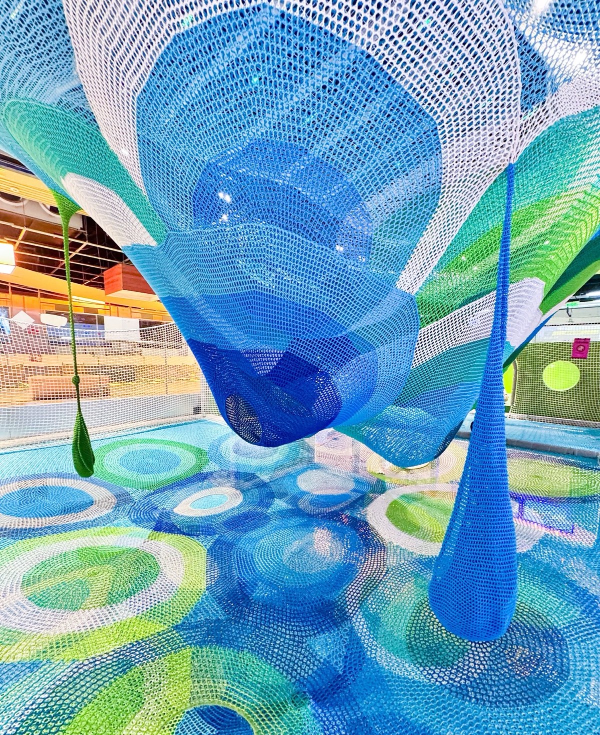 Suspended blue crochet funnel over a patterned net floor
