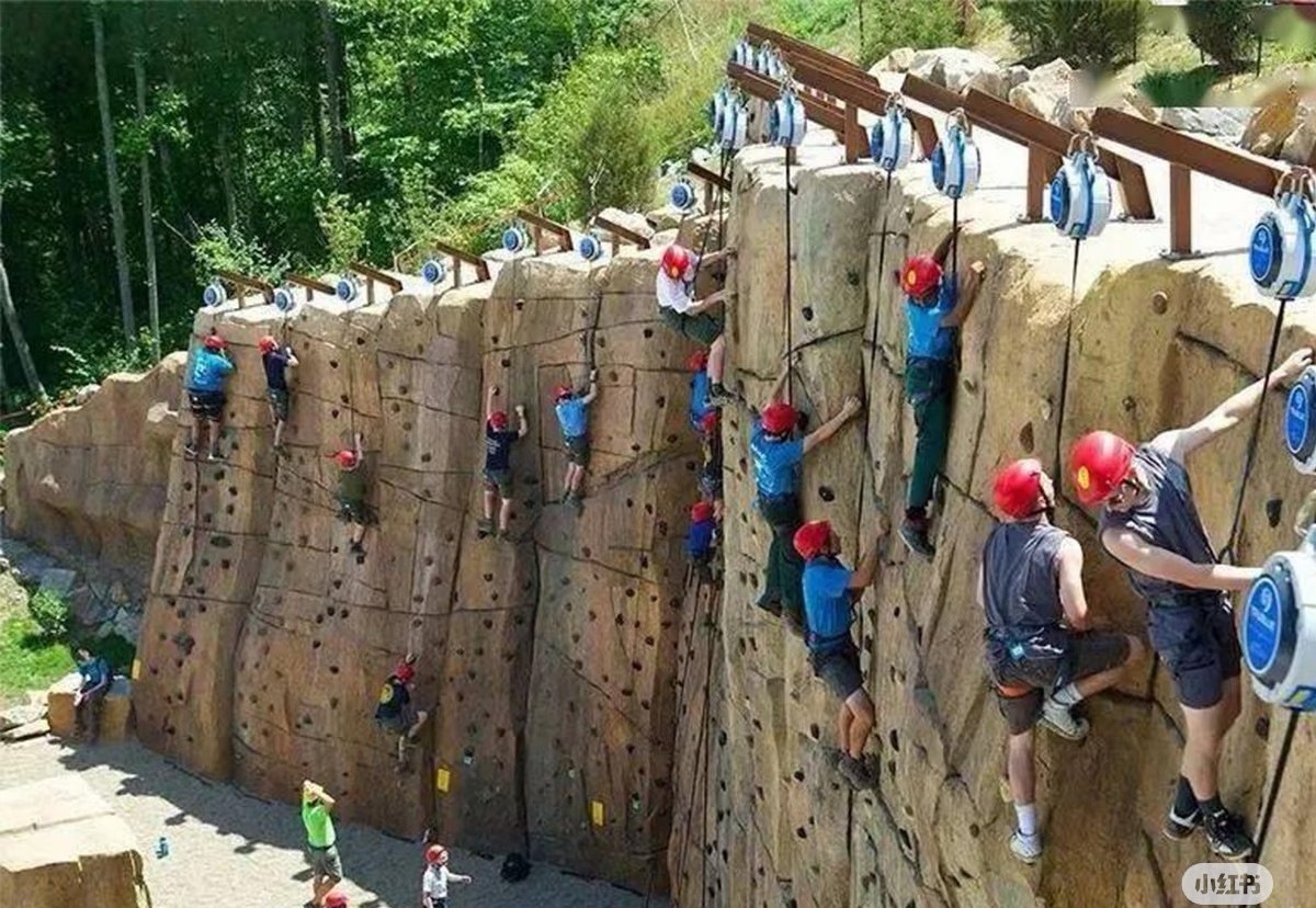 Long outdoor rock climbing wall with auto-belay lines