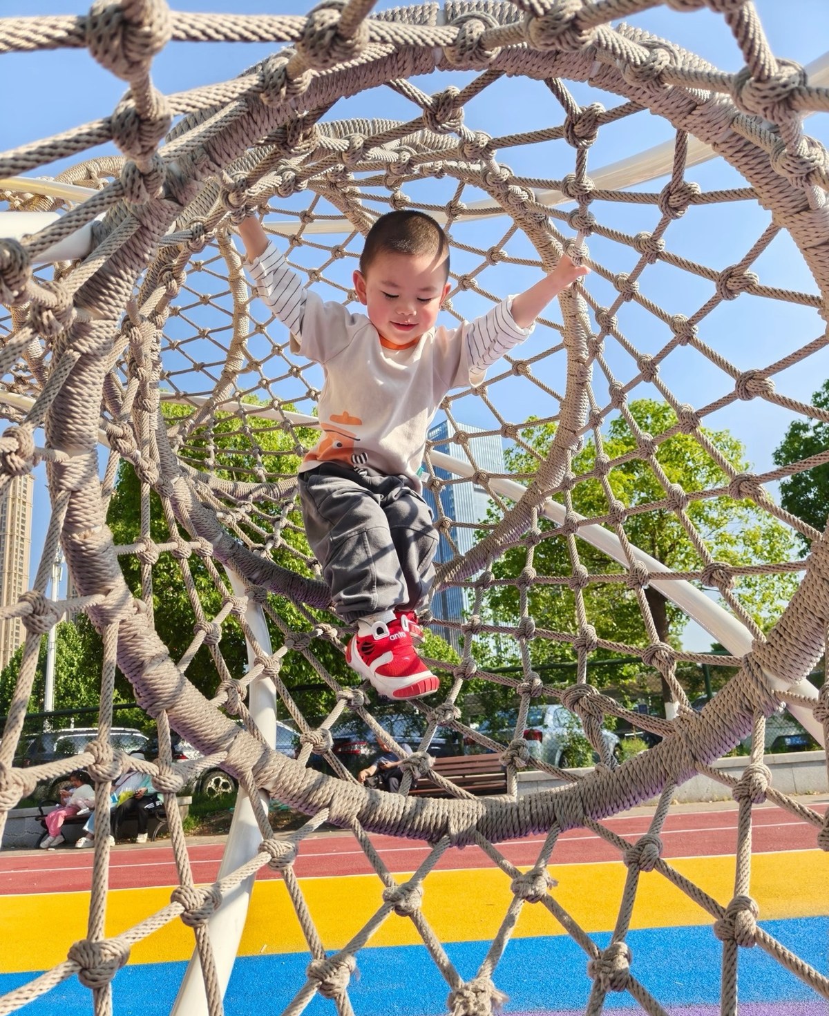 Child crossing a knotted rope tunnel