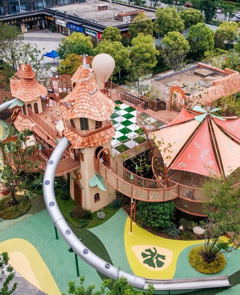 Aerial view of a fairytale tower play park with a long steel slide