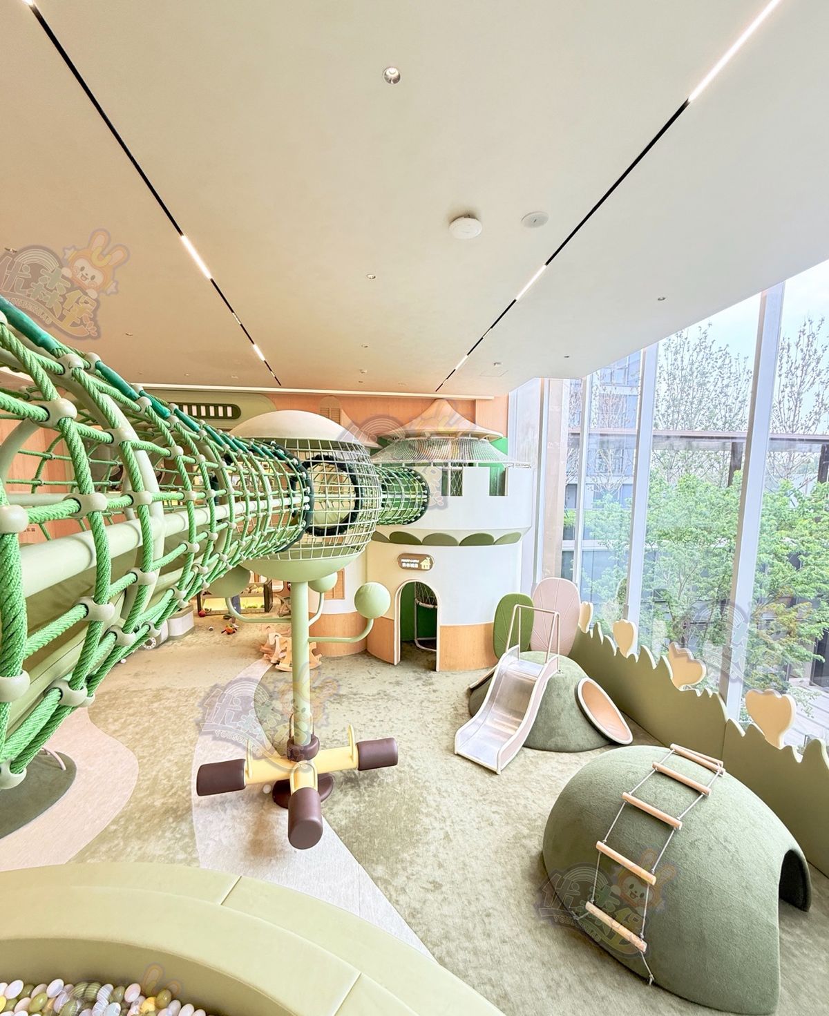Olive-green submarine play structure inside a bright indoor venue