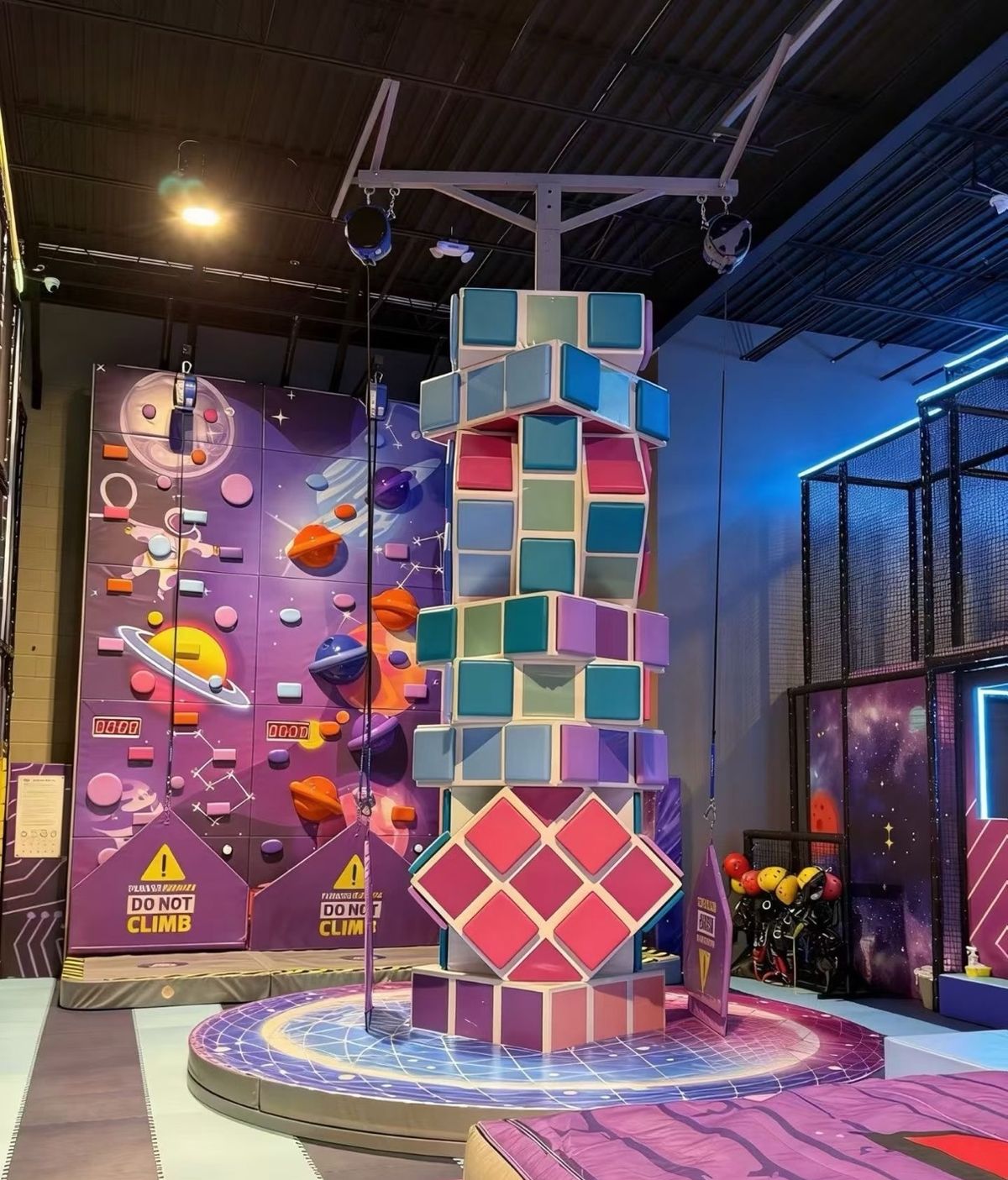Rotating cube climbing tower with a space themed climbing wall
