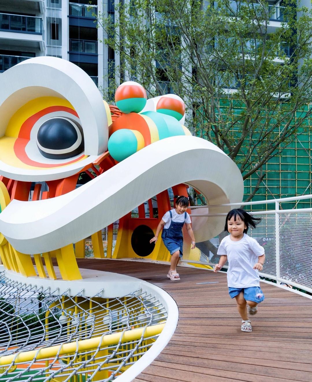 Lion-dance sculpture playground deck with children running across