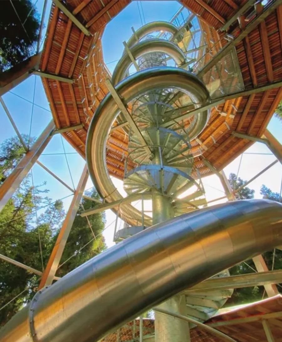Stainless steel spiral slide winding down an outdoor tower