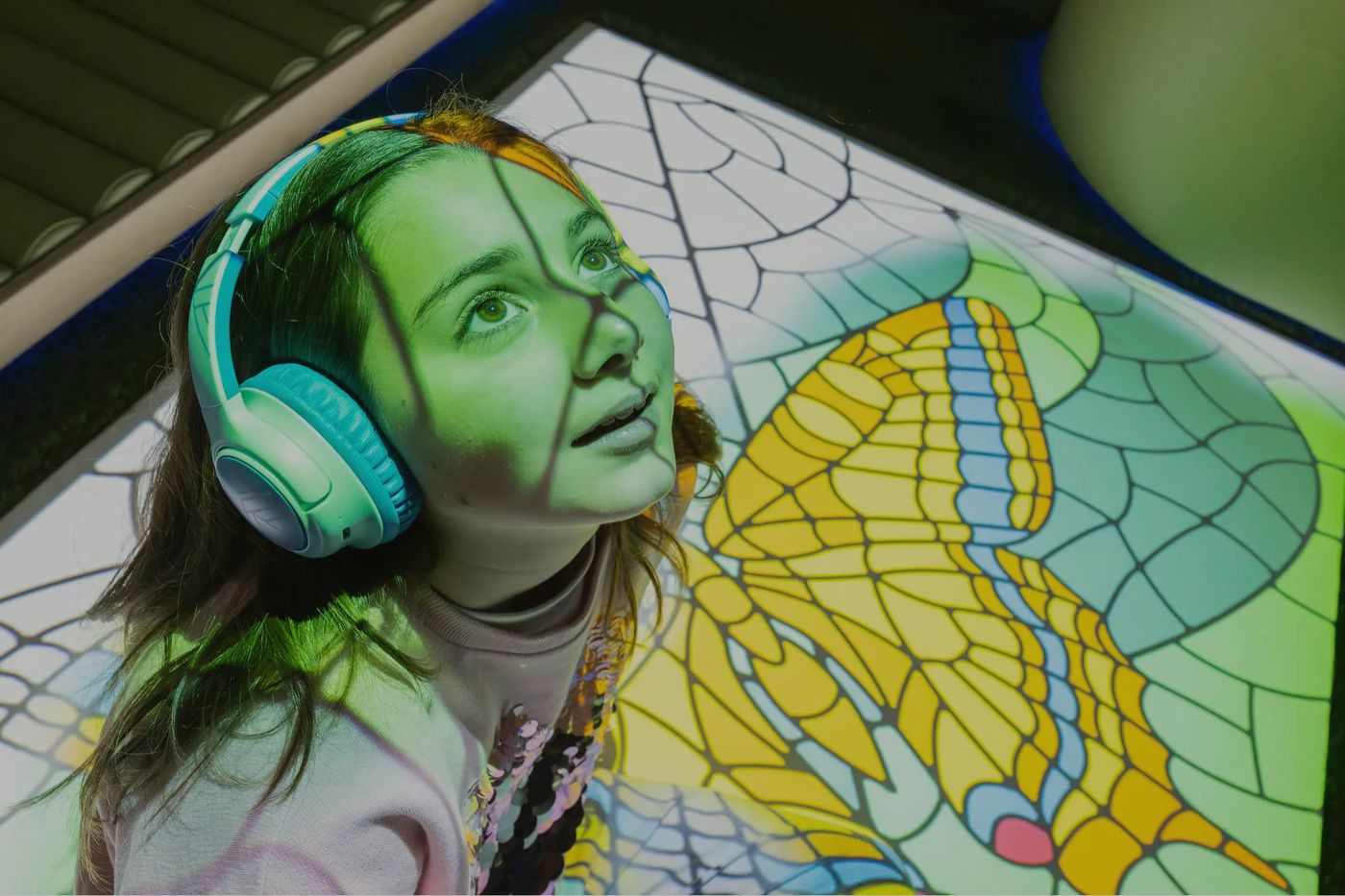 Child experiencing projected butterfly artwork in a SuntonSense sensory space