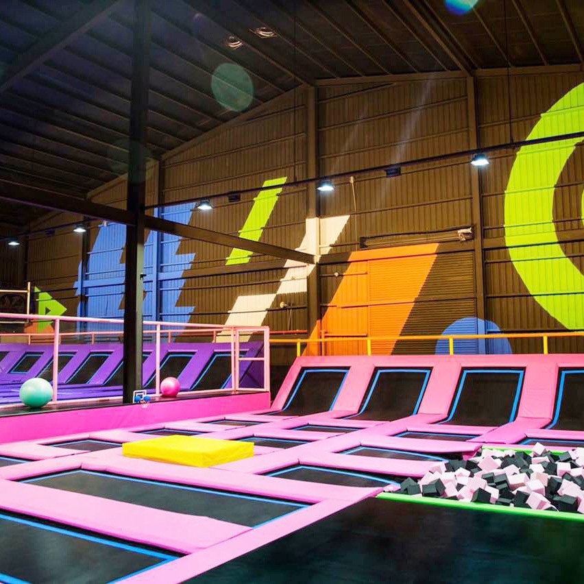 Pink trampoline courts with angled wall beds and a foam pit corner